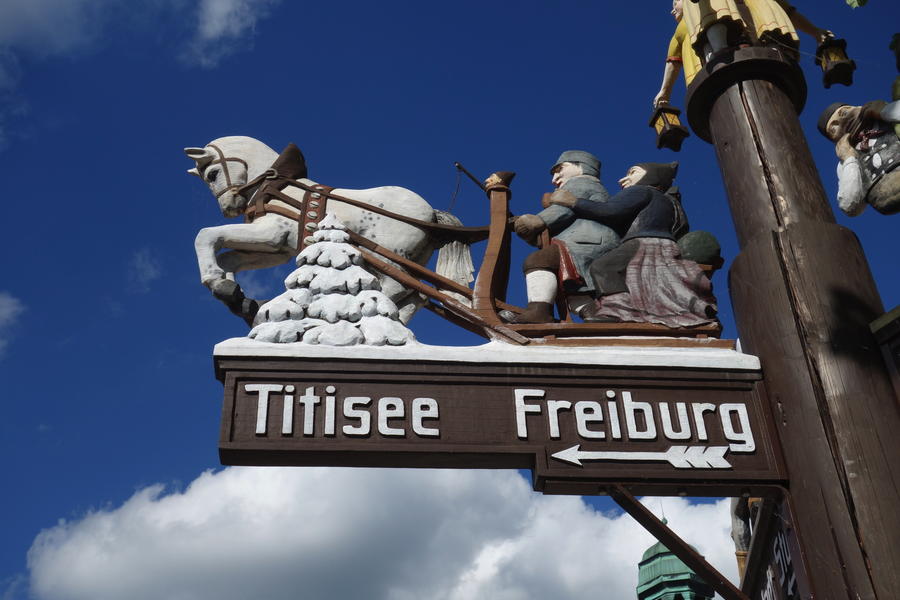 Typical Signs with handmade (carved) symbols for routes, directing to Titisee and Freiburg, in the Black Forest.