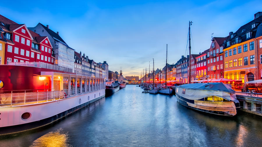 Nyhavn with its picturesque harbor with old sailing ships and colorful facades of old houses in Copenhagen, Denmark.