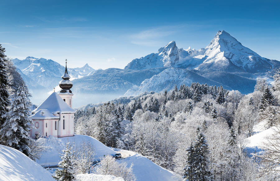 Panoramic view of beautiful winter wonderland mountain scenery in the Alps with pilgrimage church of Maria Gern and famous Watzmann summit in the background, Berchtesgadener Land, Bavaria, Germany