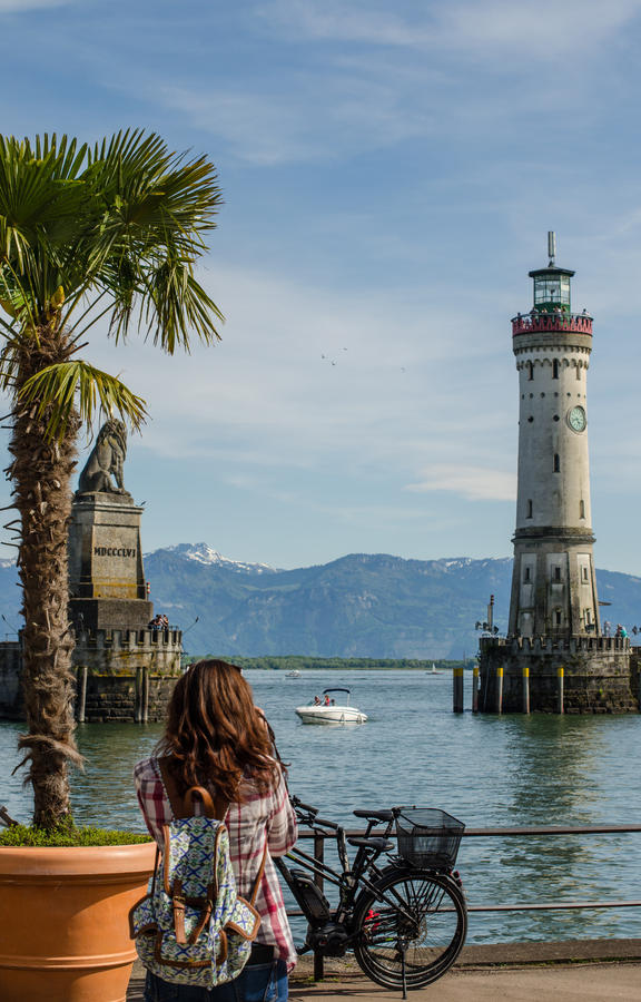 Girl making a photo of Lindau port in Germany