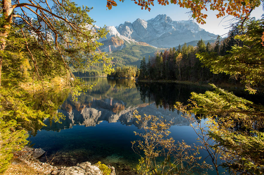 Alpine landscape with perfect sky, with the German Alps mountains reflected in the Eibsee lake on a sunny day . Majestic Autumn Scenery. Eibsee, Bavaria