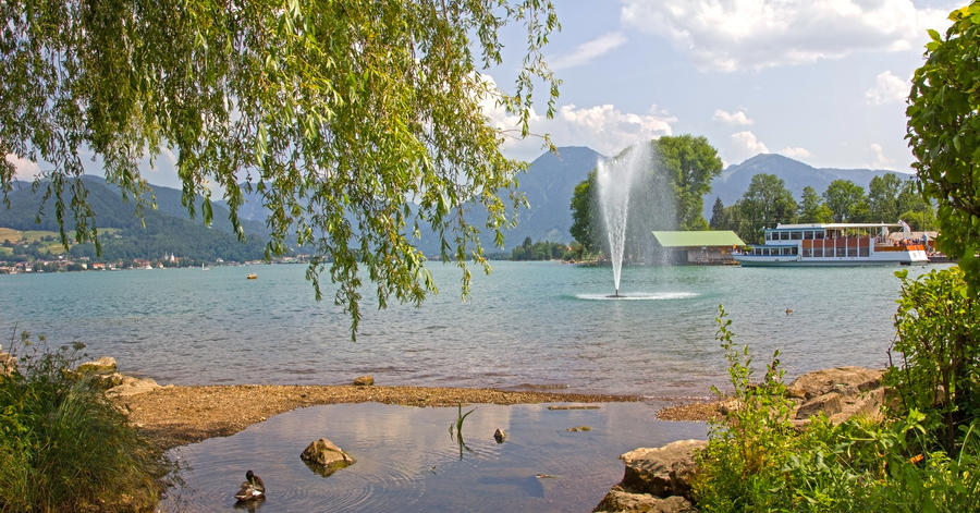 idyllic cove at lake tegernsee with passenger liner and fountain, bavarian landscape