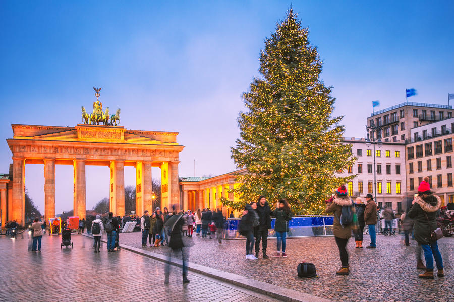 Berlin, Germany.  Classic view of Christmas tree at background of famous Brandenburger Tor (Brandenburg Gate), one of the best-known landmarks and national symbols of Germany, in twilight.