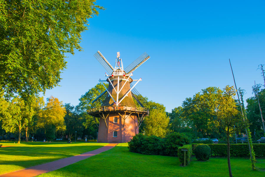 Old windmill in town park with big tree, Bad Zwischenahn, Lower Saxony, Germany.