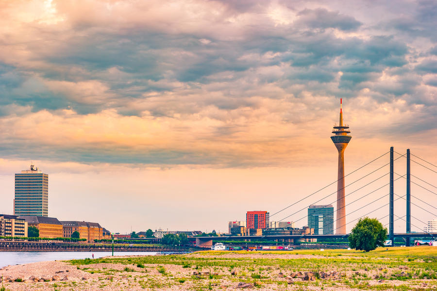 Looking at Media Harbor at Rhine-River in Dusseldorf in Germany. Rhine-Tower and famous buildings in gentle sunset light. Beautiful and colorful cityscape of the german city