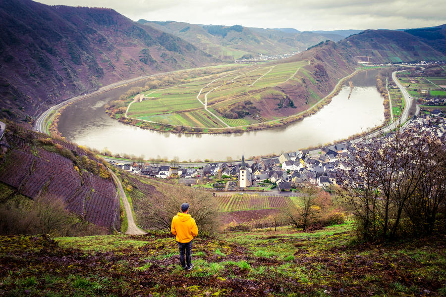 young man in the mountains looking down at the river Mosel by Moselschleife Bremm Germany Cochem
