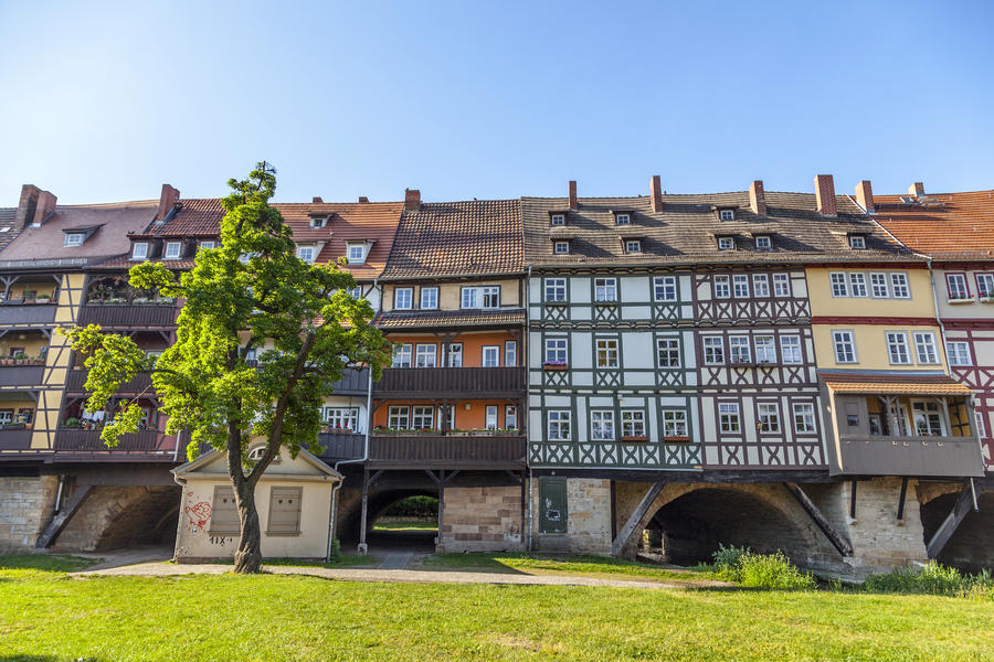 Houses on Kraemerbruecke - Merchants Bridge in Erfurt, Germany.The river gera flows under the famous bridge.