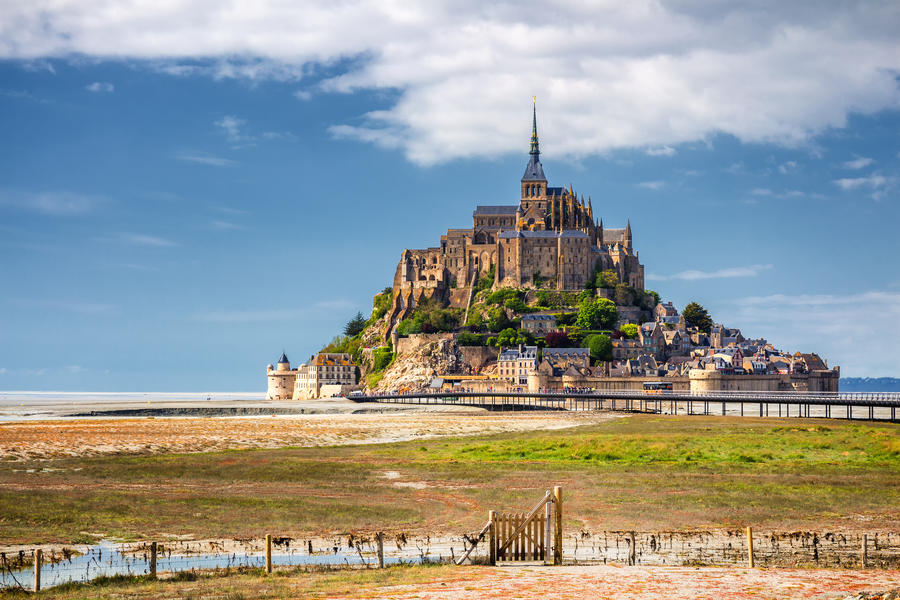 Beautiful panoramic view of famous Le Mont Saint-Michel tidal island with blue sky. Normandy, northern France