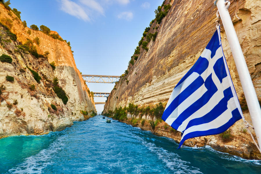 Corinth channel in Greece and greek flag on ship - travel background