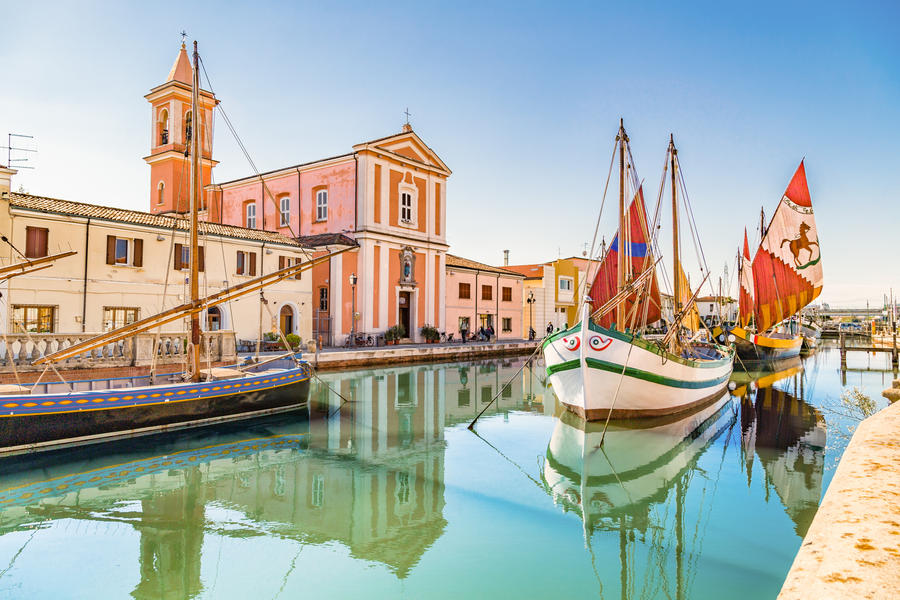 Church and ancient saiboats on Leonardesque gat in Cesenatico in Italy