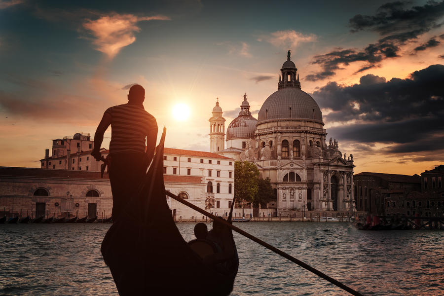 Silhouette of Venezian gondolier punting gondola in Grand canal.