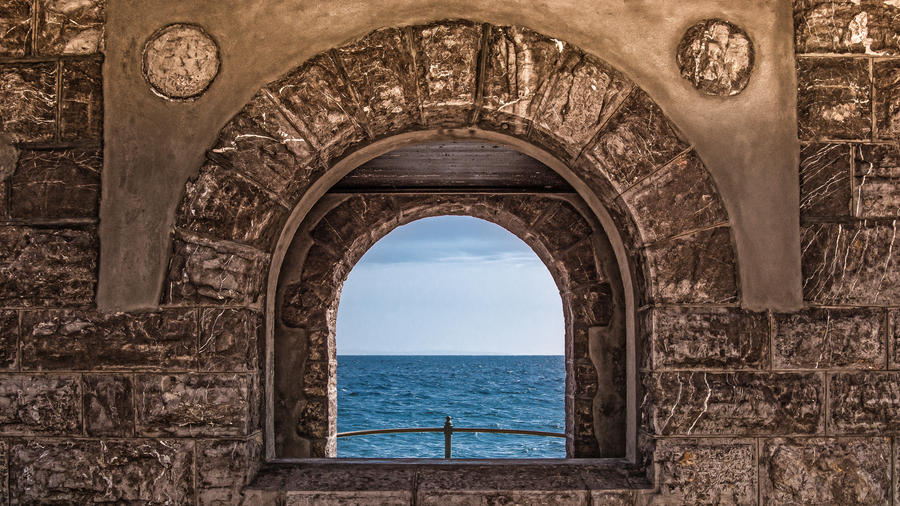 Scenic view through window on the stone wall, looking to the blue sea and sky with white clouds. Opatija,Croatia,Europe.