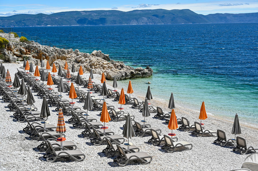 empty stone beach with sunshades in Rabac Croatia may 2019