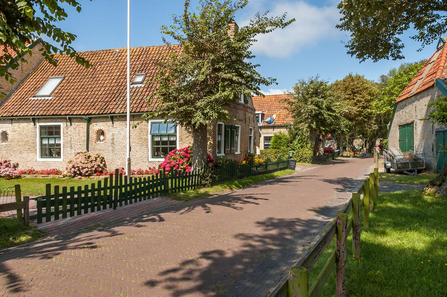 Street with old Dutch commander houses in the town of Hollum on the West-Frisian island Ameland, Netherlands