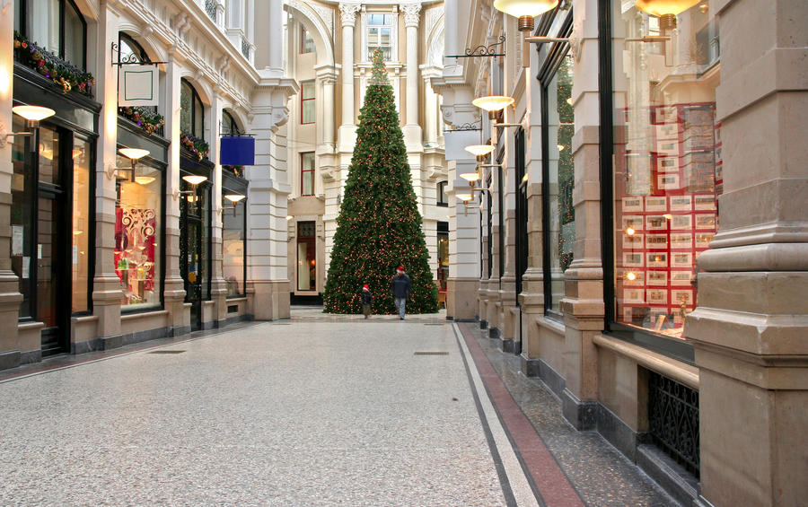 Shopping arcade with christmas tree, including a father and son wearing father christmas caps