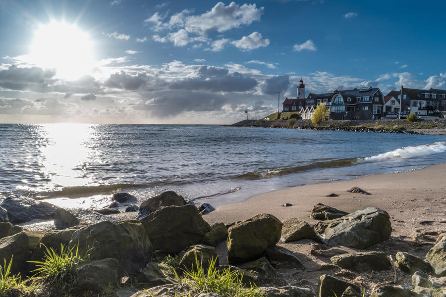 Lighthouse on former island Urk taken from the beach with rocks and water from the lake ijselmeer, The Netherlands Urk April 2017