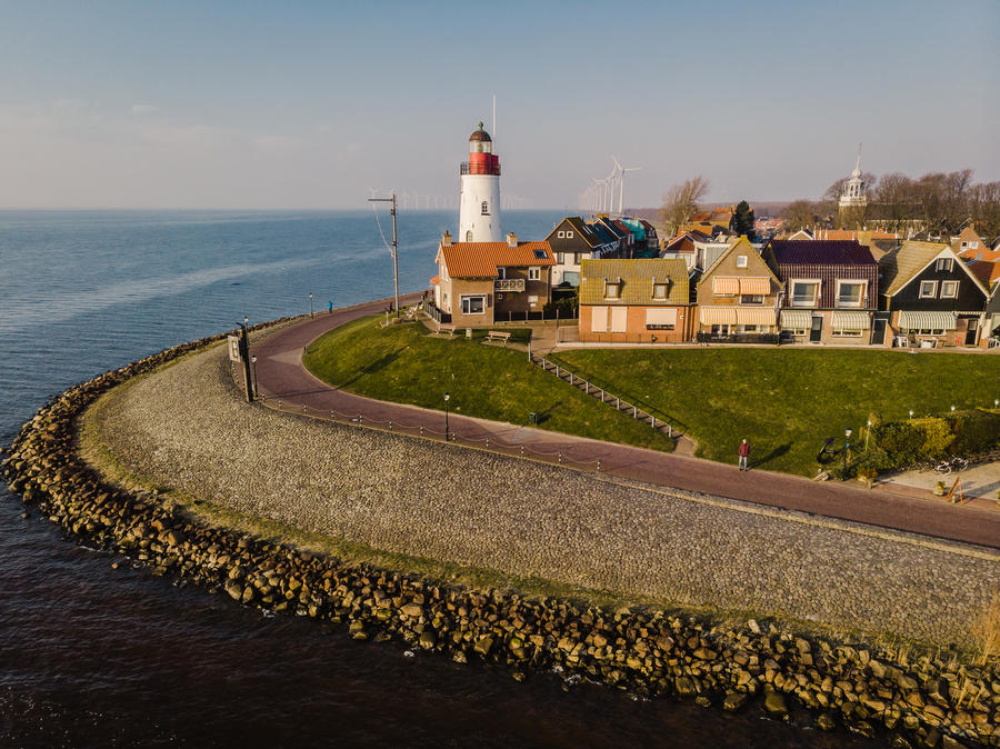 Lighthouse of urk on the rocky beach at the lake Ijsselmeer by the former island Urk Flevoland Netherlands, Bird eye view drone view of the old dutch village Urk