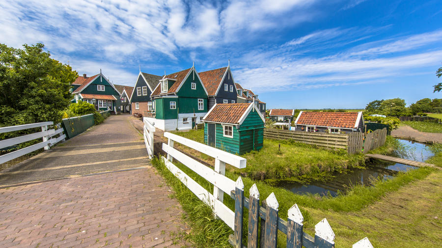Dutch village scene with wooden houses and bridge over canal on the island of Marken in the Ijsselmeer or formerly Zuiderzee, the Netherlands