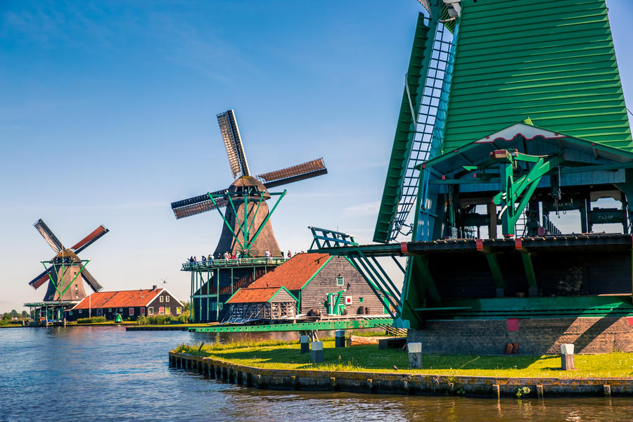 Traditional dutch windmills located by the river Zaan, in Zaanse Schans, Netherlands.