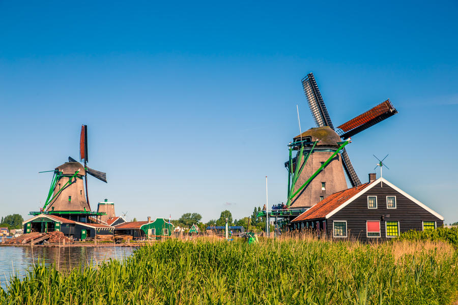 Traditional dutch windmills located by the river Zaan, in Zaanse Schans, Netherlands.