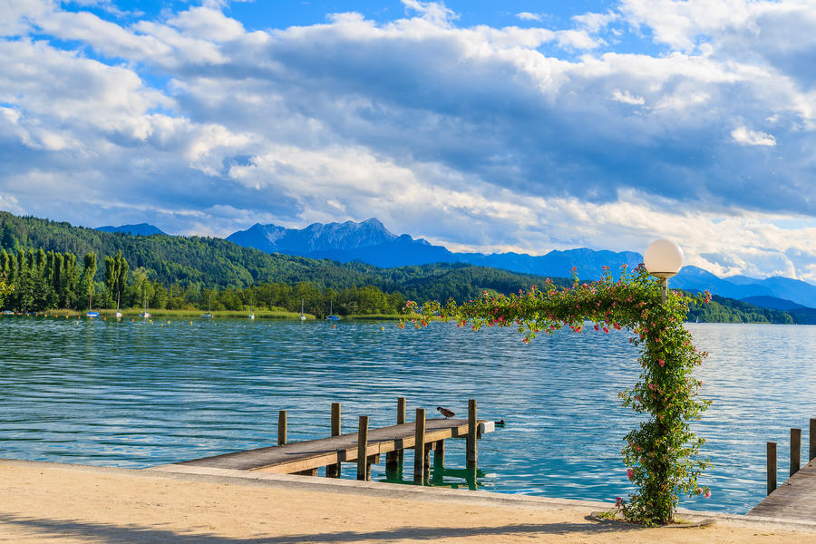 Wooden pier for mooring boats on Worthersee lake on beautiful summer day, Austria