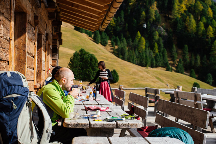 Male tourists stopped for a coffee in a quiet location and views of the mountains in the Dolomite, Alps