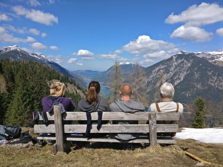 four people on a bench in front of the achensee, Austria