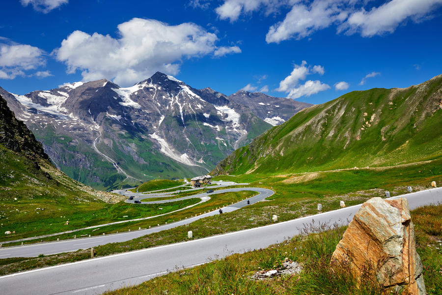Panoramic view at Pasterze Glacier Grossglockner among austrian Alps mountains summits blue sky clouds.