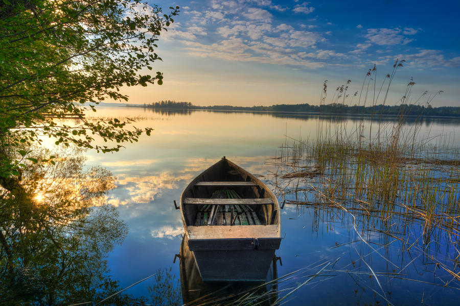 Rowing boat floating over the Lake Selment Wielki waters. Masuria, Poland.