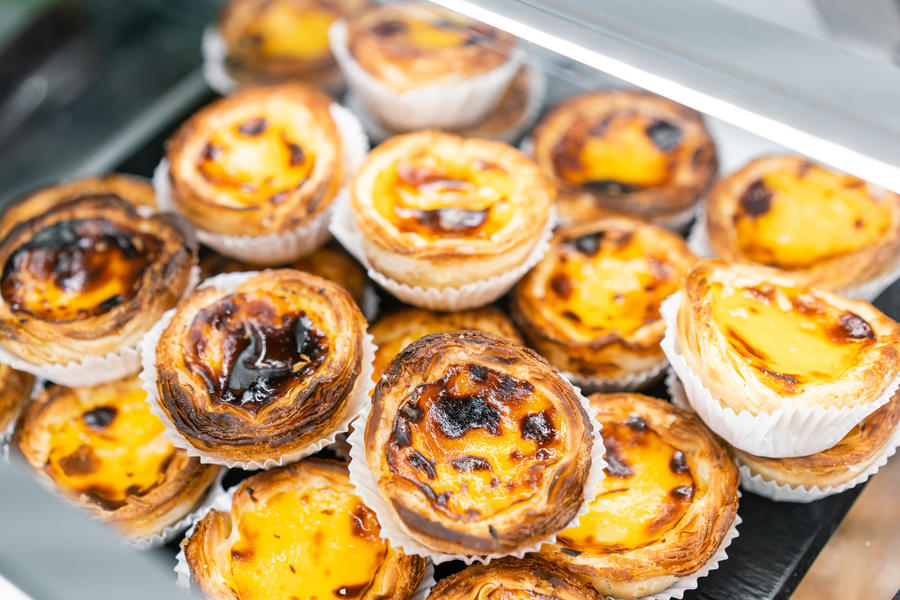 Rows of egg tart, traditional portuguese dessert, pasteis de nata, custard tarts. Cafe on the streets of Lisbon, Portugal