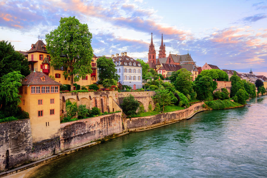 The Old Town of Basel with red stone Munster cathedral and the Rhine river, Switzerland, in dramatic sunset light