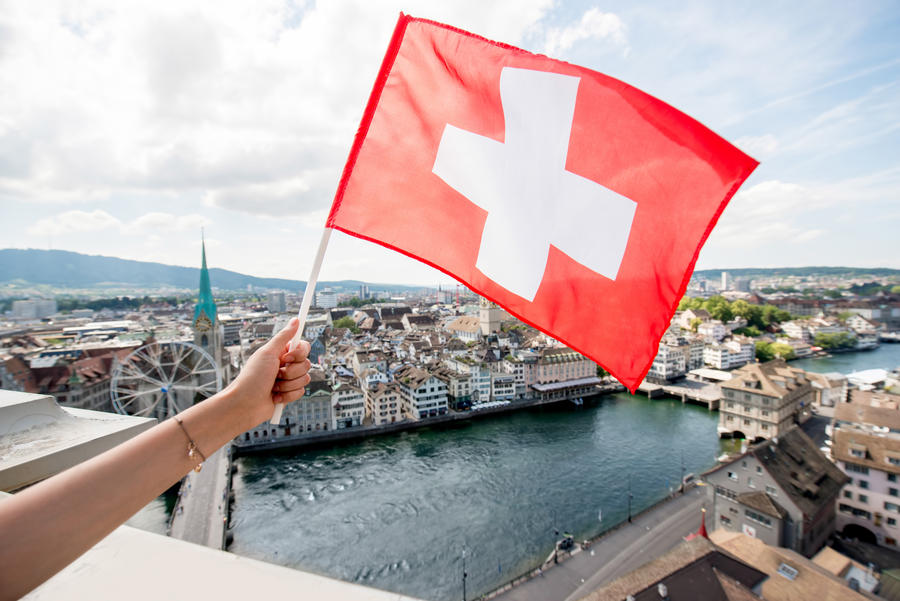 Holding a swiss flag on Zurich cityscape backround in Switzerland