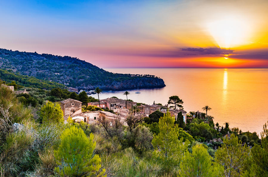 Beautiful sunset at the coast of Majorca Spain island, quaint village at the seaside of Deia, Mediterranean Sea, Balearic islands.