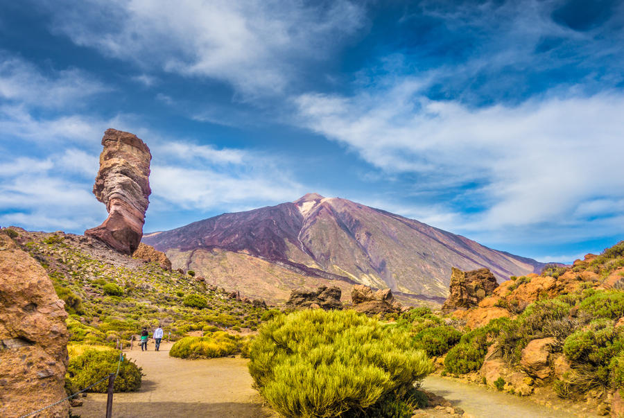 Panoramic view of unique Roque Cinchado unique rock formation with famous Pico del Teide mountain volcano summit in the background on a sunny day, Teide National Park, Tenerife, Canary Islands, Spain