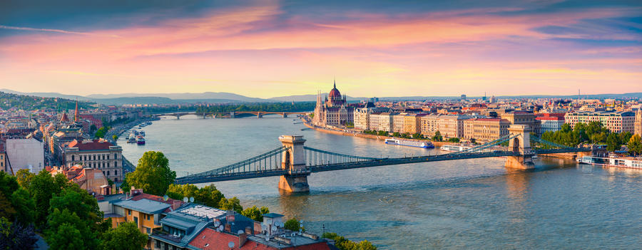 Panoramic cityscape of Hungarian parliament building with famous Chain Bridge on the Danube river. Colorful spring  sunset in Budapest, Hungary, Europe. Artistic style post processed photo.