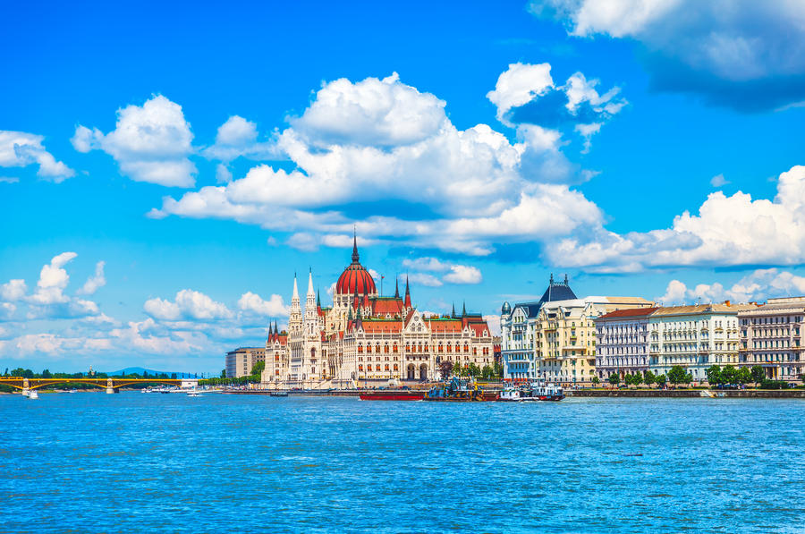 Panorama with building of hungarian parliament at danube river in budapest city hungary blue sky clouds