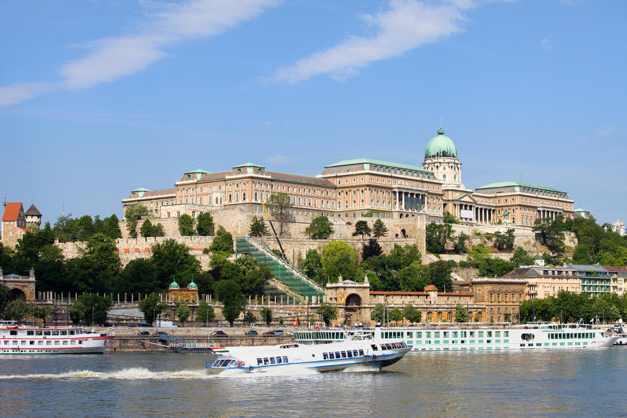 Buda Castle historic landmark and passenger boats on the Danube River in Budapest, Hungary.