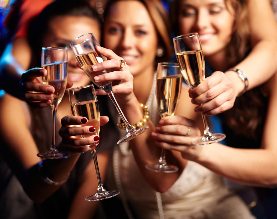 Group of partying girls clinking flutes with sparkling wine