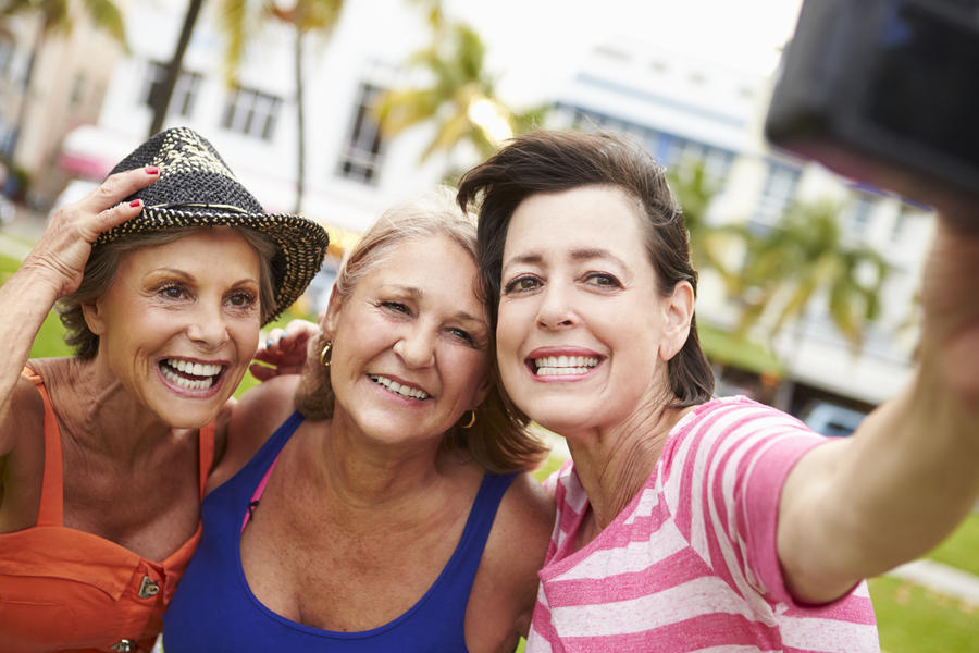 Three Senior Female Friends Taking Selfie In Park