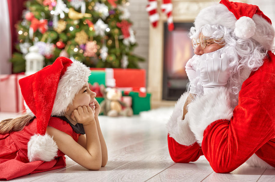 Santa Claus and cute girl getting ready for Christmas.