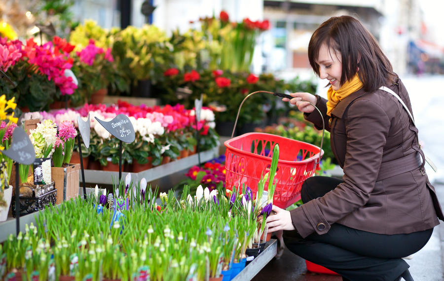 Beautiful girl selecting flowers at market