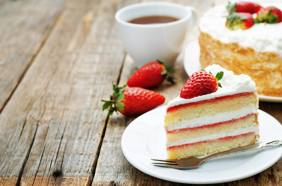 cake with cream and strawberries on a dark wood background. tinting. selective focus