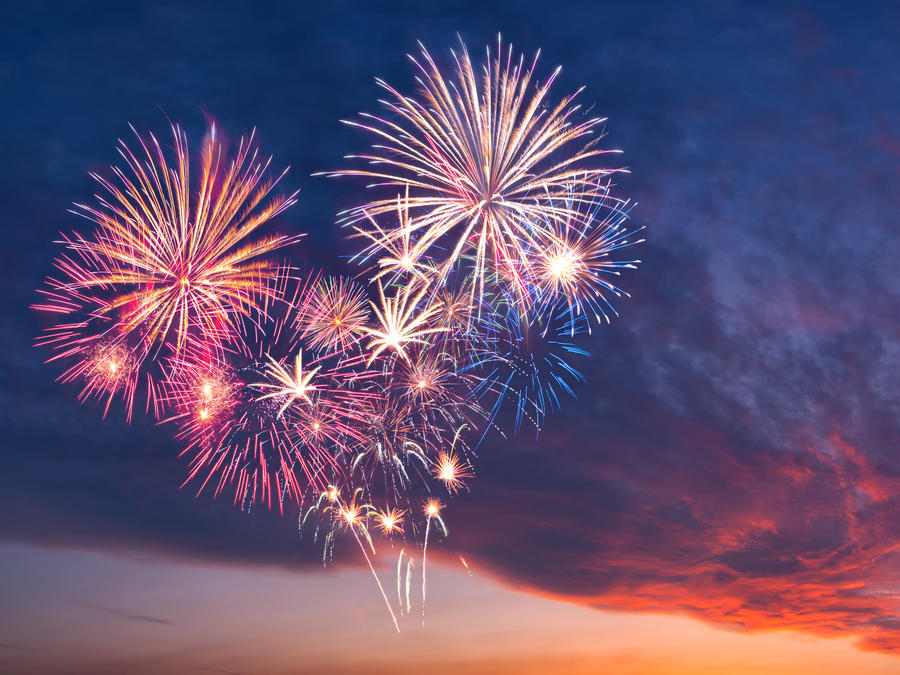 Beautiful colorful holiday fireworks in the evening sky with majestic clouds,  long exposure