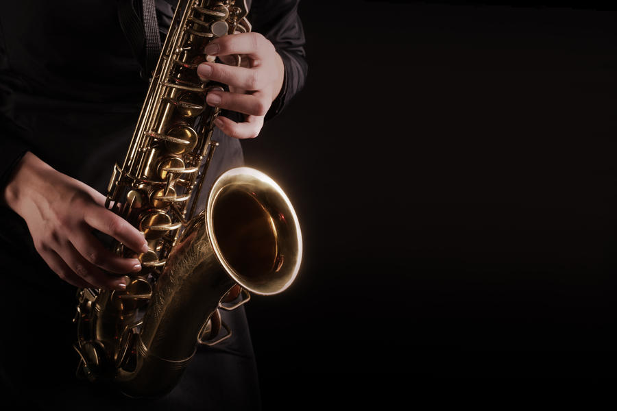 Saxophone Player hands Saxophonist playing jazz music. Alto sax musical instrument closeup