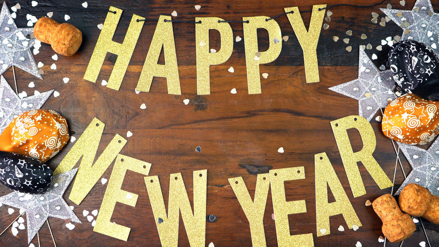 Happy New Year gold letters bunting and decorations on dark wood table overhead