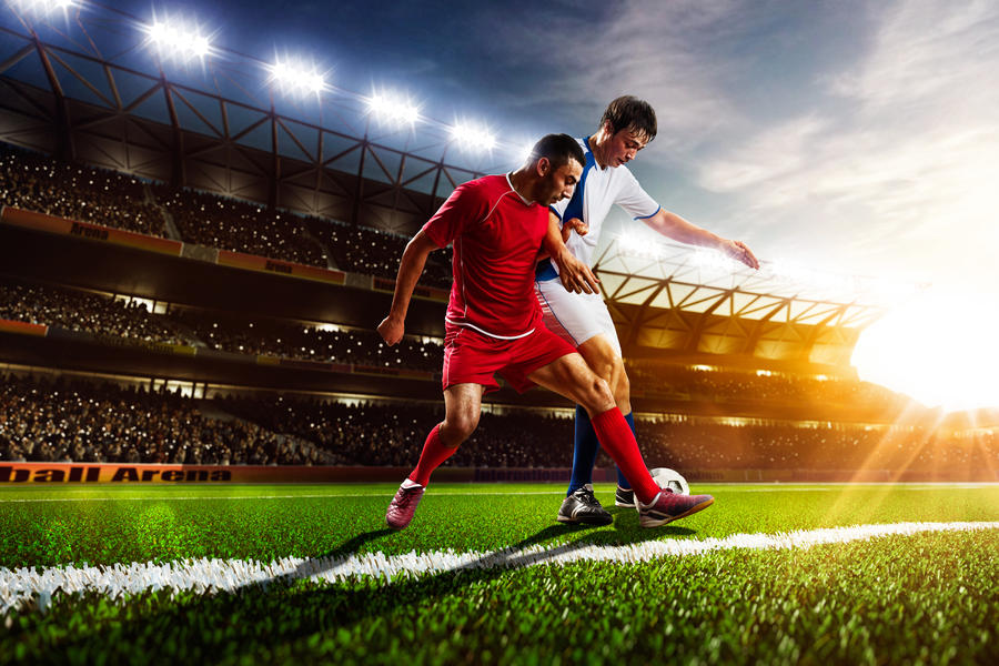 Soccer players in action on sunset stadium background panorama