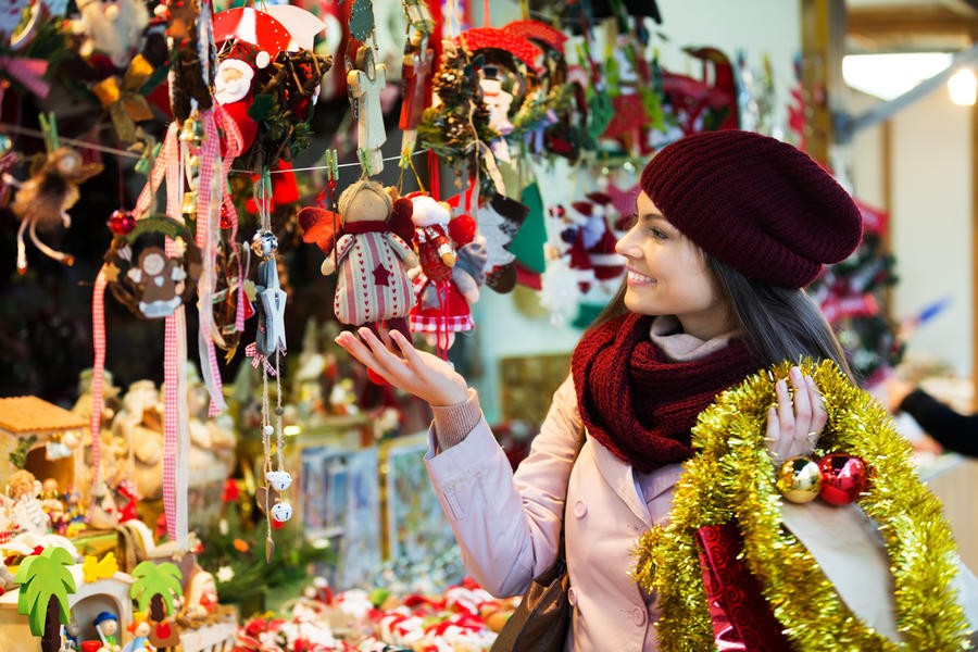 Young happy woman shopping at festive fair before Christmas