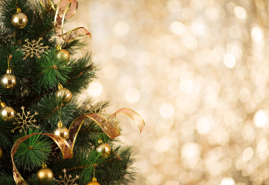 Gold Christmas background of de-focused lights with decorated tree