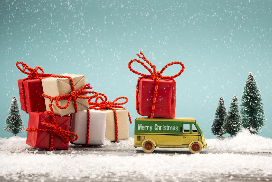 Toy car carrying a Christmas gift in a snowy landscape