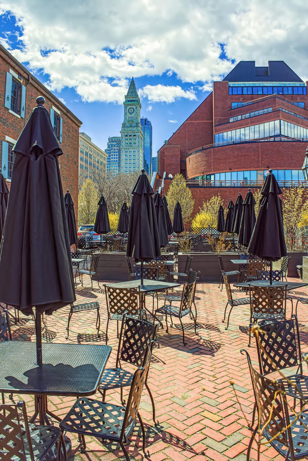 Custom House Tower and street cafe with umbrellas at Long Wharf of Boston, Massachusetts, the United States.